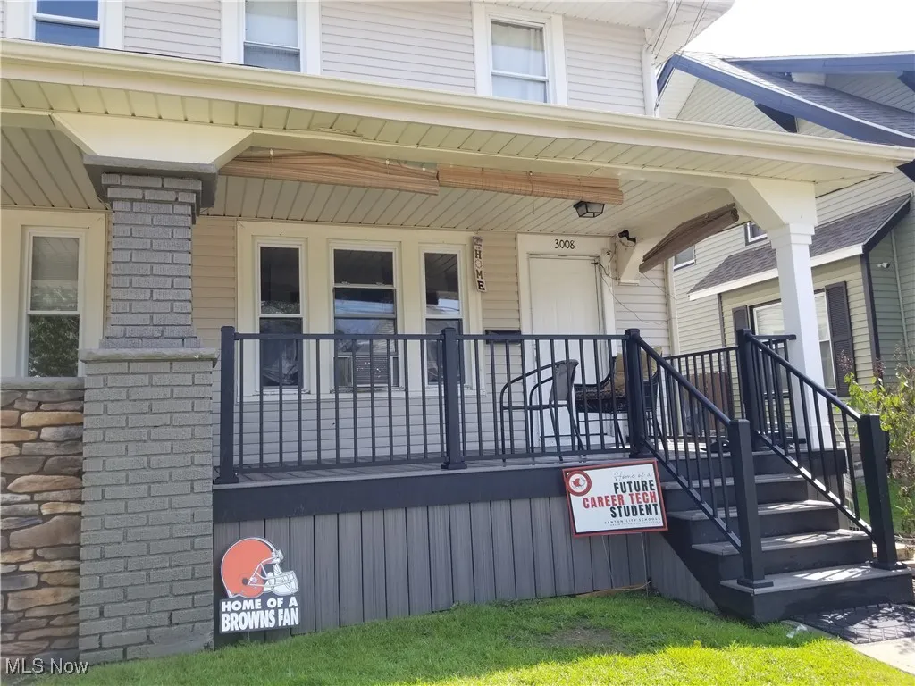 View of exterior entry with a porch and stone siding
