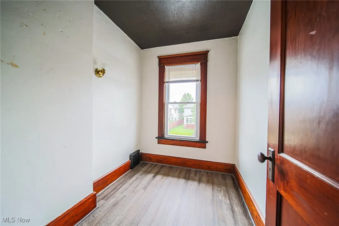 Spare room with baseboards, wood finished floors, and a textured ceiling