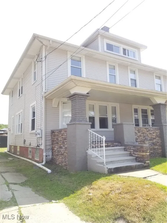 American foursquare style home featuring a porch