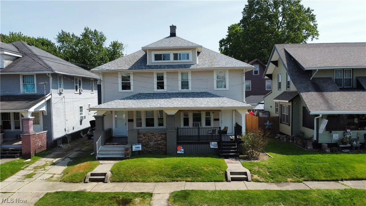Traditional style home featuring a porch, a front lawn, and roof with shingles