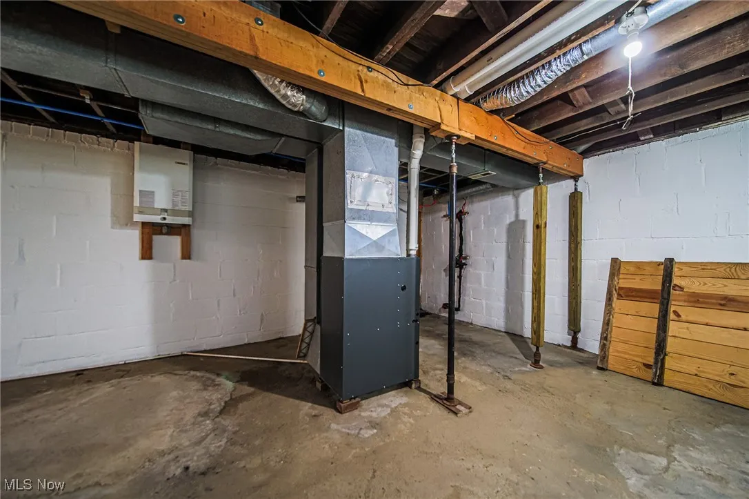 Unfinished below grade area featuring heating unit