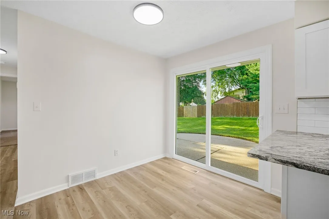 Unfurnished dining area featuring light wood-style floors and baseboards