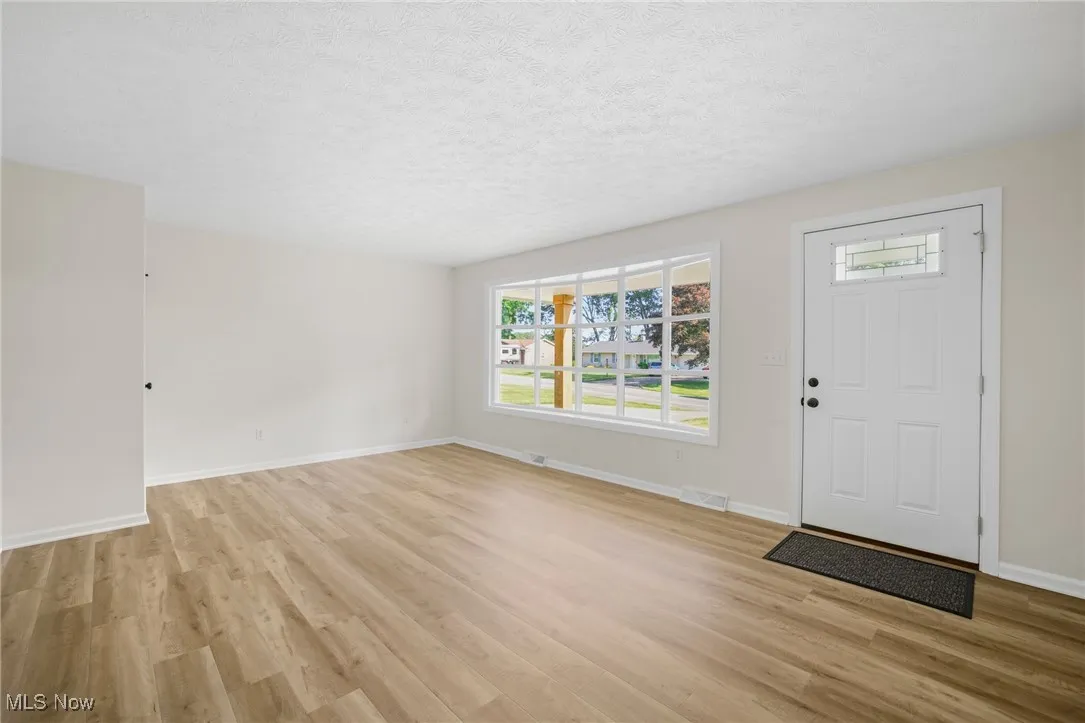 Entryway with light wood-type flooring and a textured ceiling