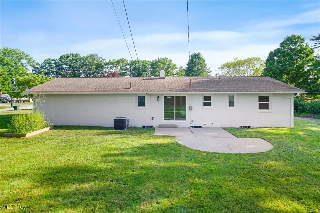Back of property with a patio area, a lawn, and a chimney