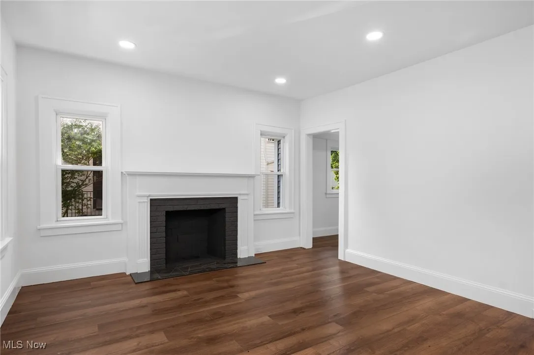Unfurnished living room with a brick fireplace and recessed lighting