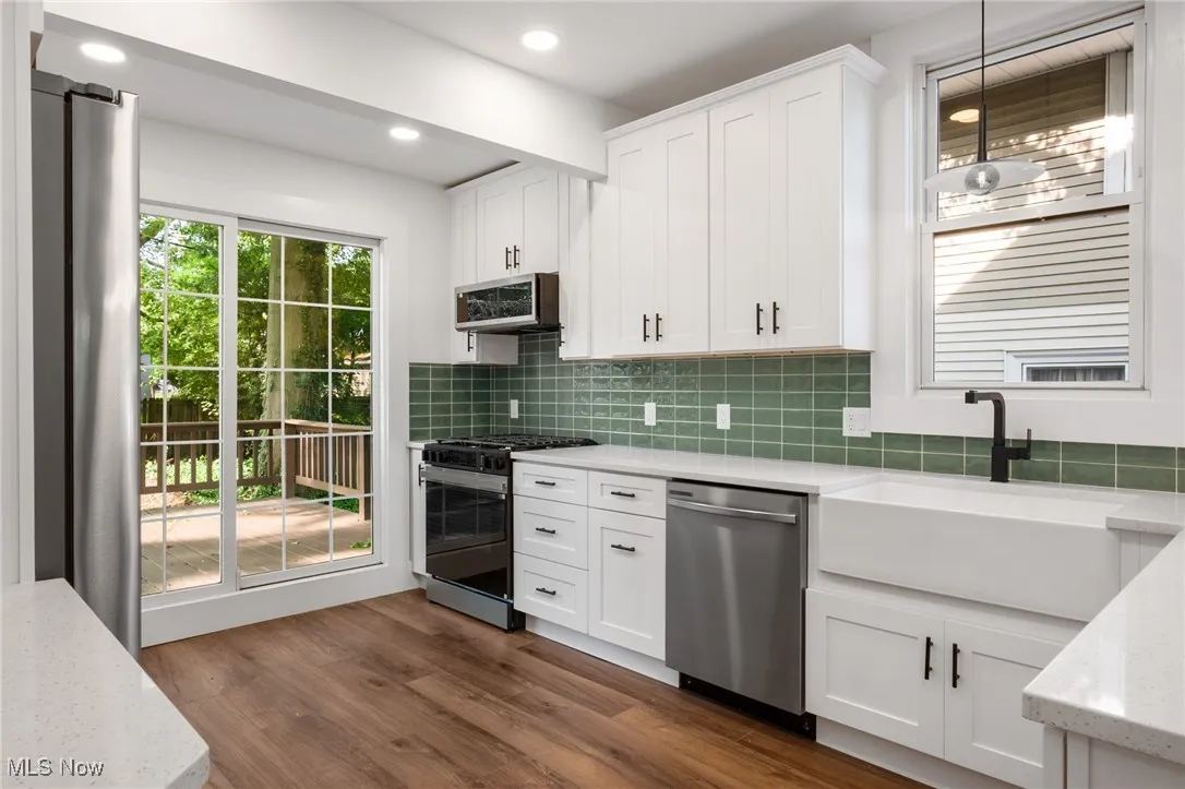 Kitchen with appliances with stainless steel finishes, tasteful backsplash, white cabinetry, and recessed lighting