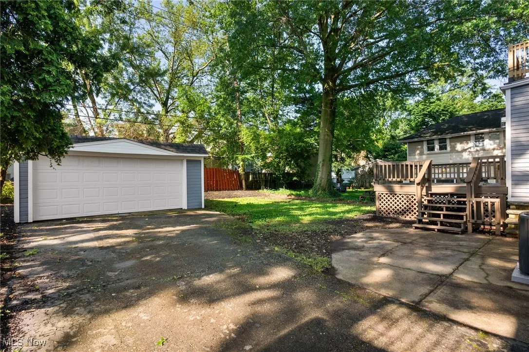 View of yard with a deck, an outbuilding, and a detached garage