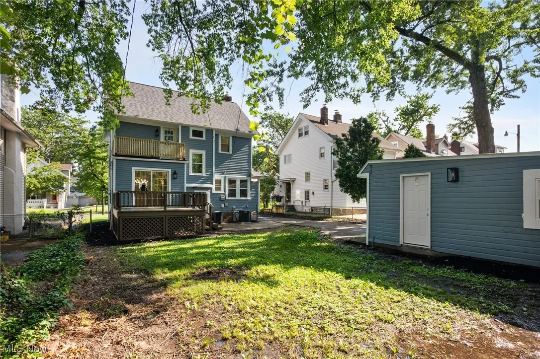 Rear view of house with a balcony, a deck, and an outbuilding