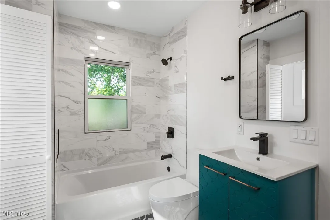 Bathroom featuring vanity, bathing tub / shower combination, and a closet