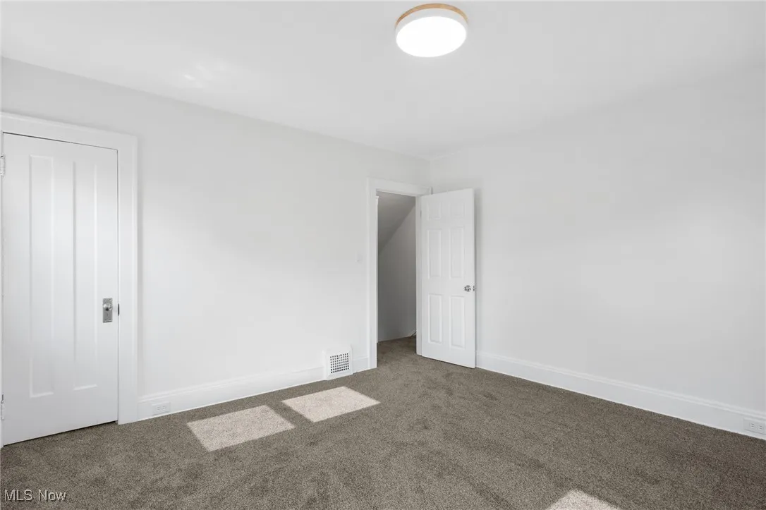 Unfurnished bedroom with carpet floors and baseboards