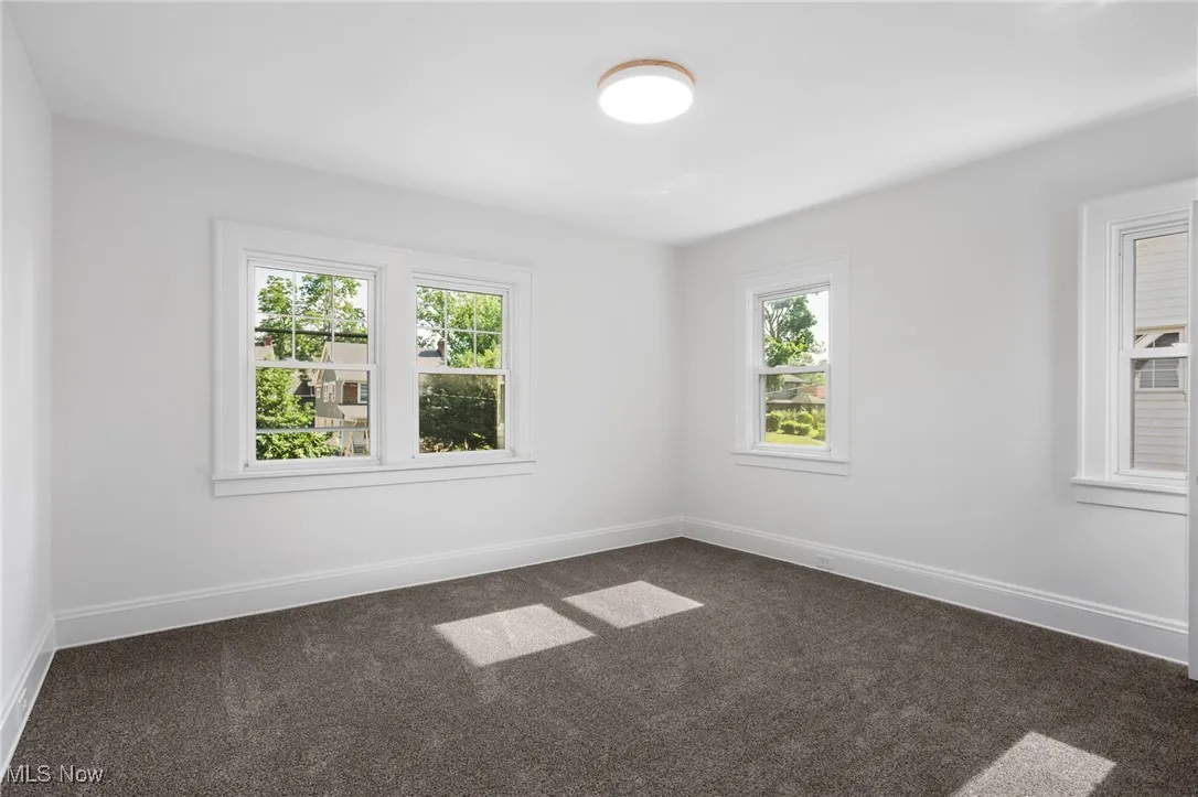 Empty room featuring dark carpet
