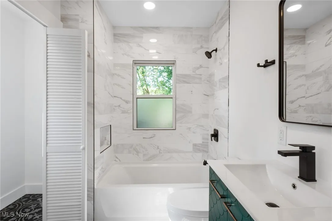 Full bathroom with a closet, vanity, shower / bath combination, and recessed lighting