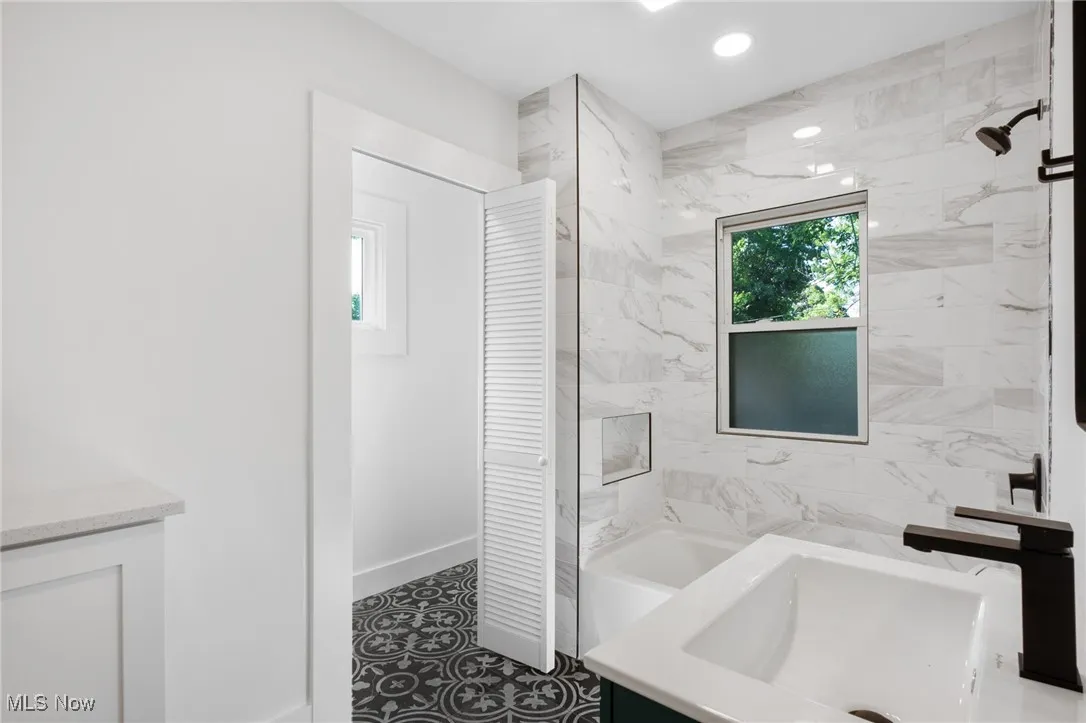 Full bathroom with vanity, a closet, recessed lighting, tile patterned floors, and a bathtub