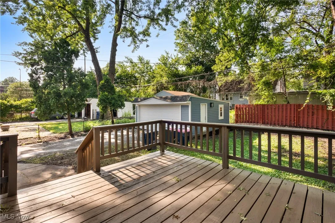 Wooden deck with a detached garage and an outdoor structure