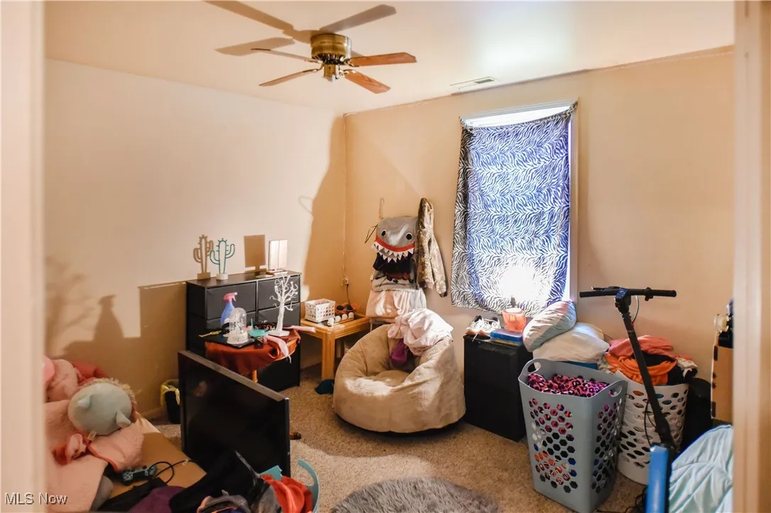 Carpeted bedroom with ceiling fan