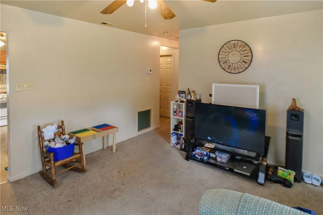 Living room with a ceiling fan and carpet floors