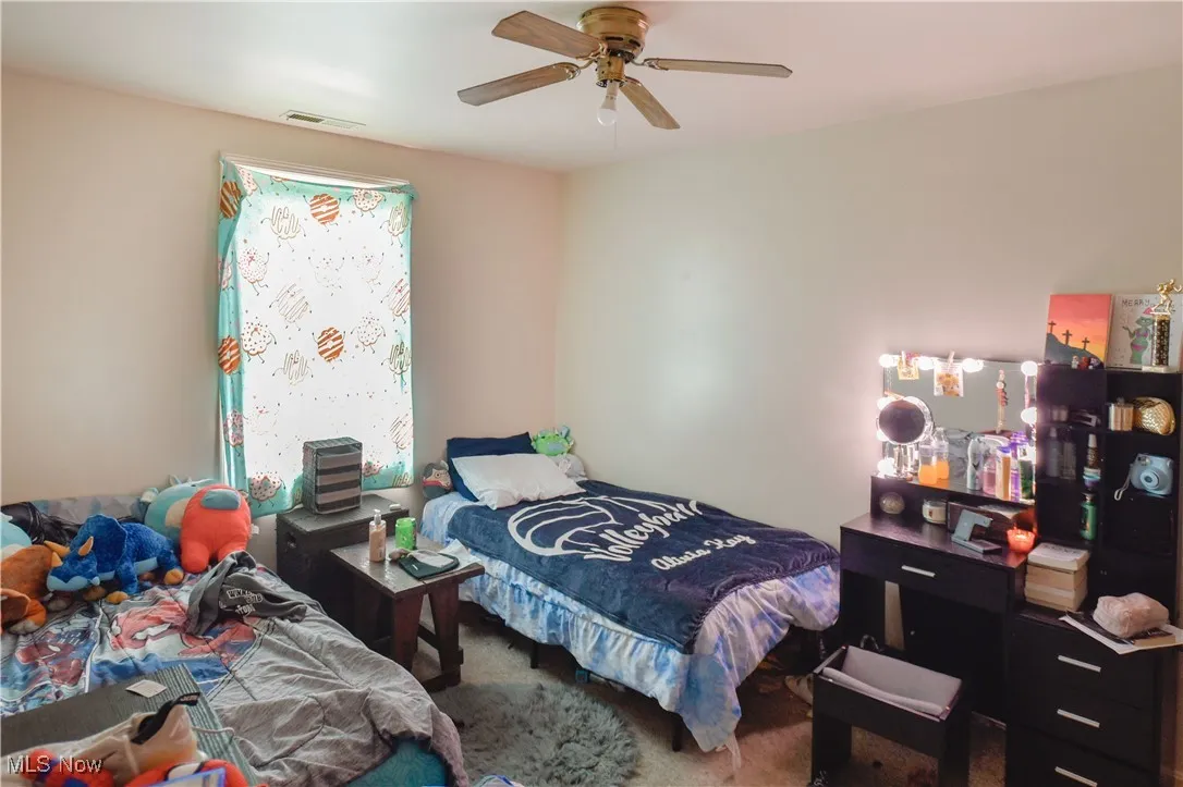 Carpeted bedroom with ceiling fan