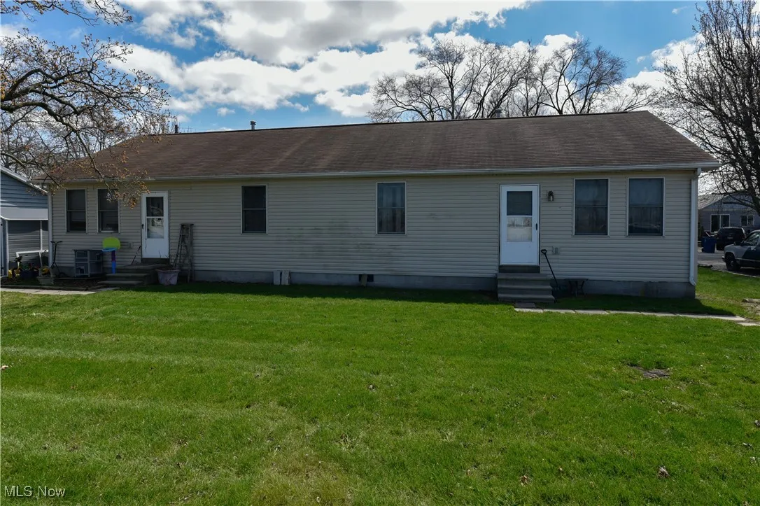 View of front of property with entry steps and a front yard