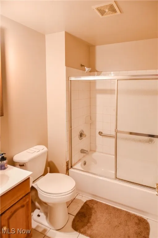 Full bathroom featuring vanity, tile patterned floors, and shower / bath combination with glass door