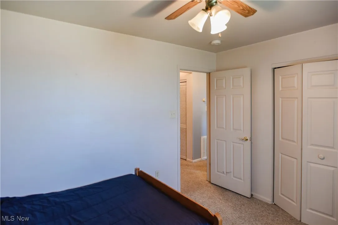 Unfurnished bedroom with light colored carpet, a closet, and ceiling fan