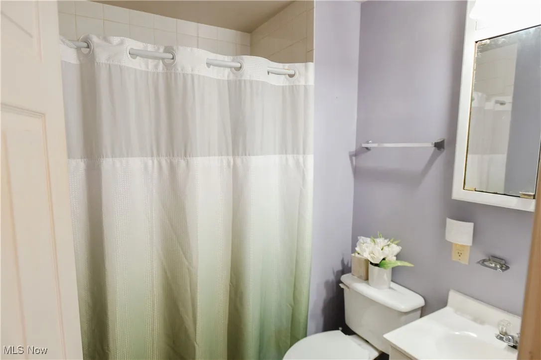 Full bathroom with vanity and curtained shower