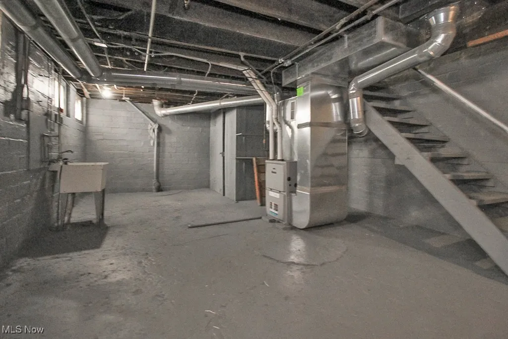 Basement featuring heating unit and a sink