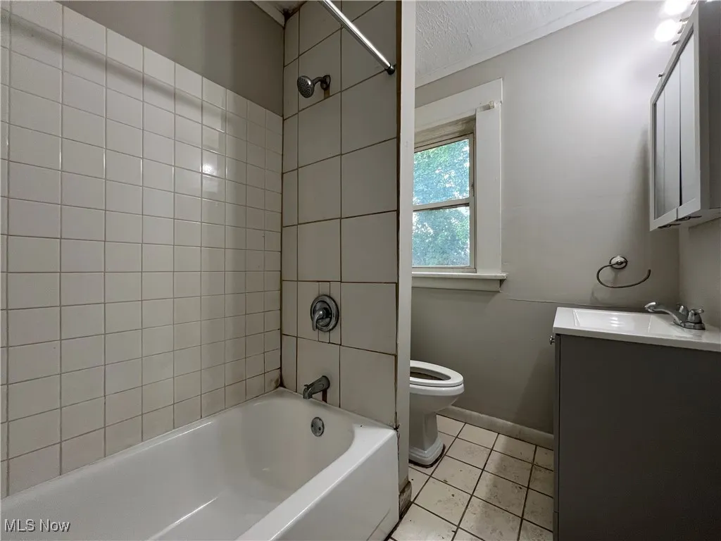 Bathroom with vanity, tile patterned flooring, and tub / shower combination