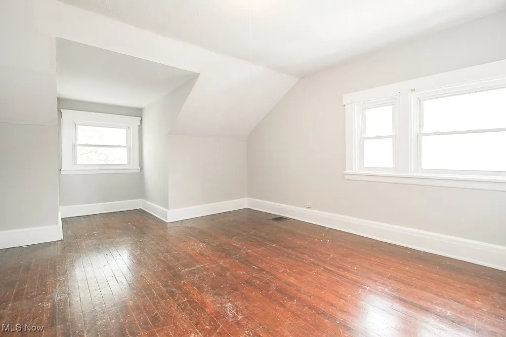 Additional living space featuring hardwood / wood-style floors and vaulted ceiling