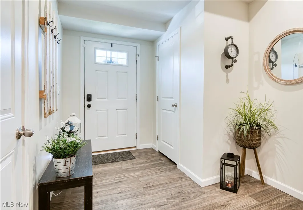 Foyer entrance featuring light wood-style flooring and baseboards