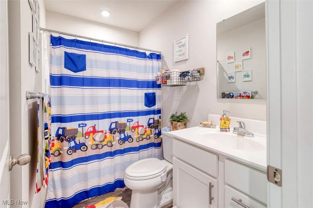 Full bath featuring vanity and curtained shower