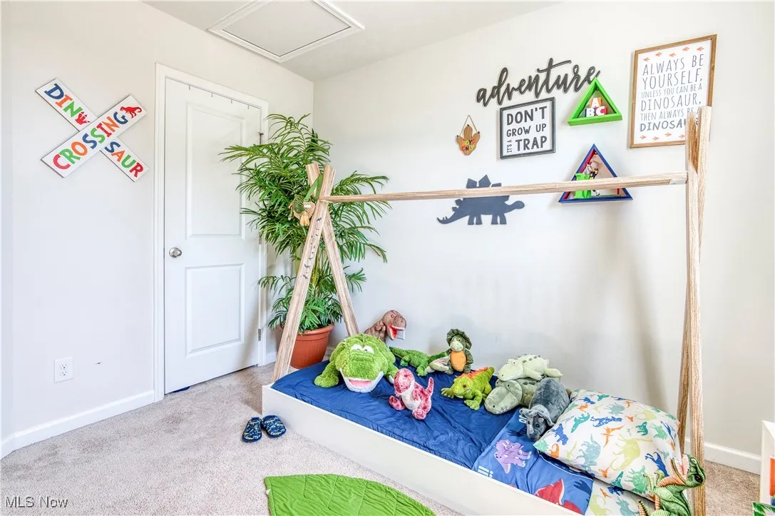 Unfurnished bedroom with carpet and attic access