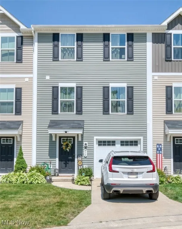 Townhome / multi-family property featuring an attached garage and concrete driveway