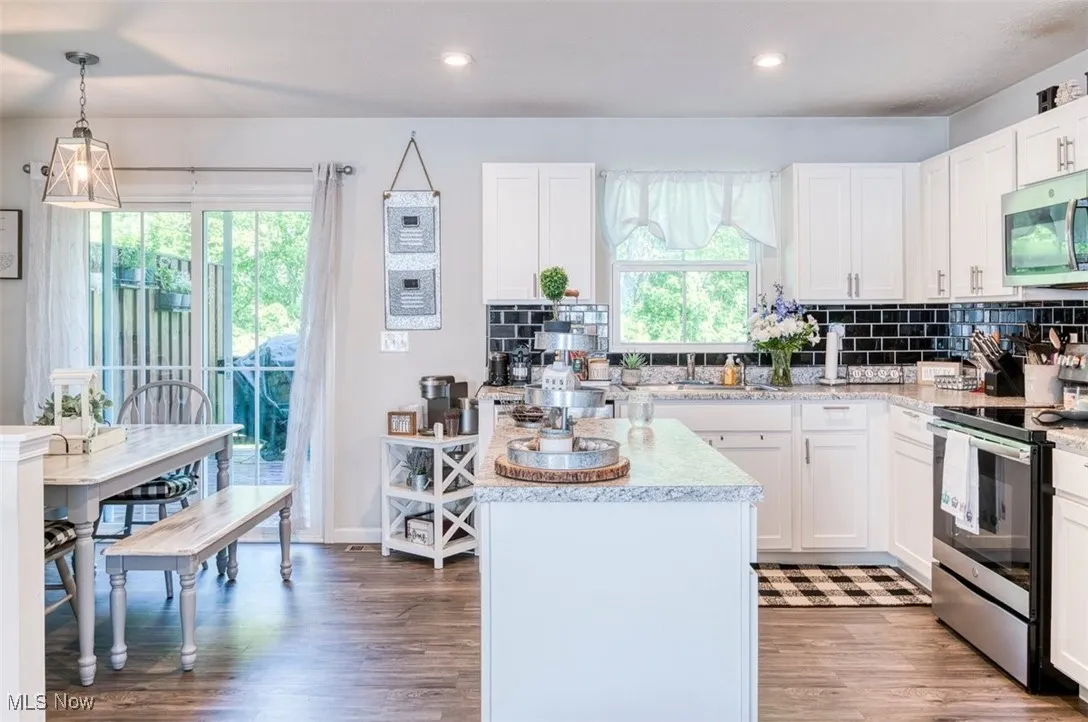 Kitchen featuring stainless steel appliances, healthy amount of natural light, white cabinetry, light wood-type flooring, and recessed lighting