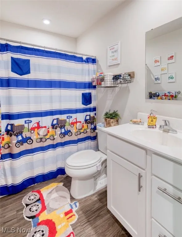 Full bath featuring vanity, wood finished floors, recessed lighting, and a shower with curtain