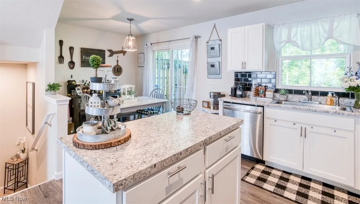 Kitchen featuring dishwasher, light countertops, and a center island