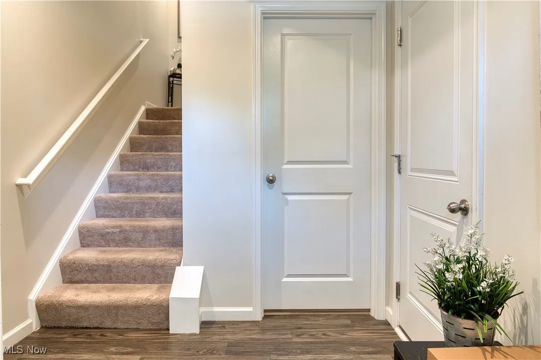 Stairs with wood finished floors and baseboards