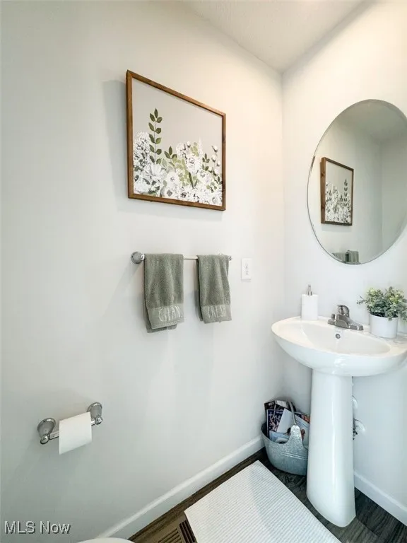 Bathroom featuring baseboards and wood finished floors