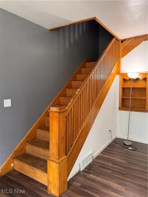 Stairs with wood finished floors and baseboards