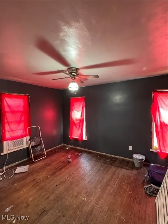 Empty room featuring hardwood / wood-style flooring and a ceiling fan