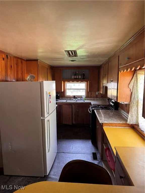 Kitchen with refrigerator and range