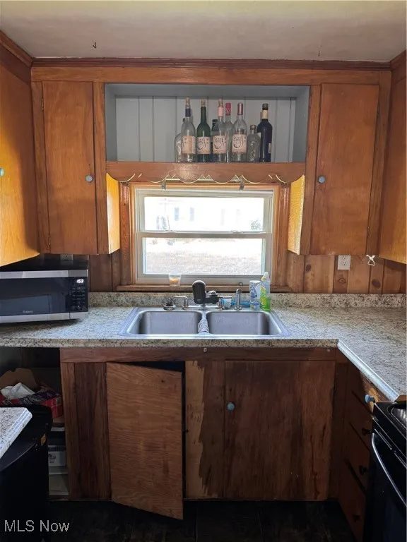 Kitchen featuring light countertops, range, and brown cabinets