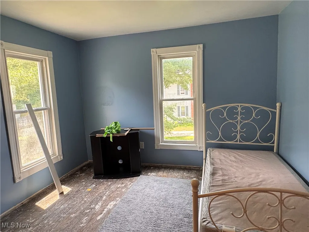 Bedroom featuring multiple windows and wood finished floors