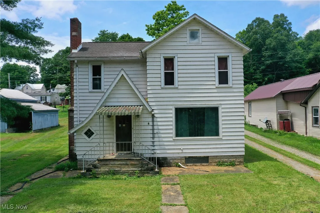 Traditional home with a chimney and a front lawn
