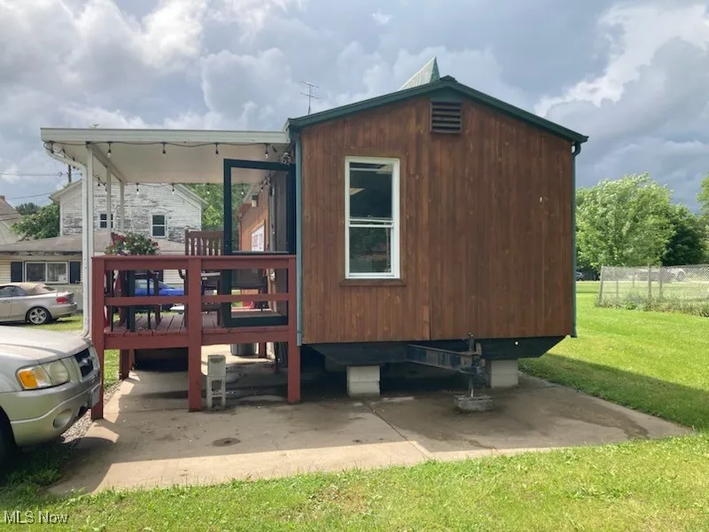 View of side of property with a lawn and a deck