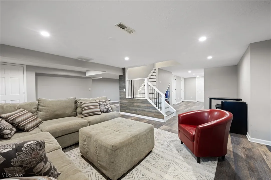 Living area featuring wood finished floors, stairs, and recessed lighting