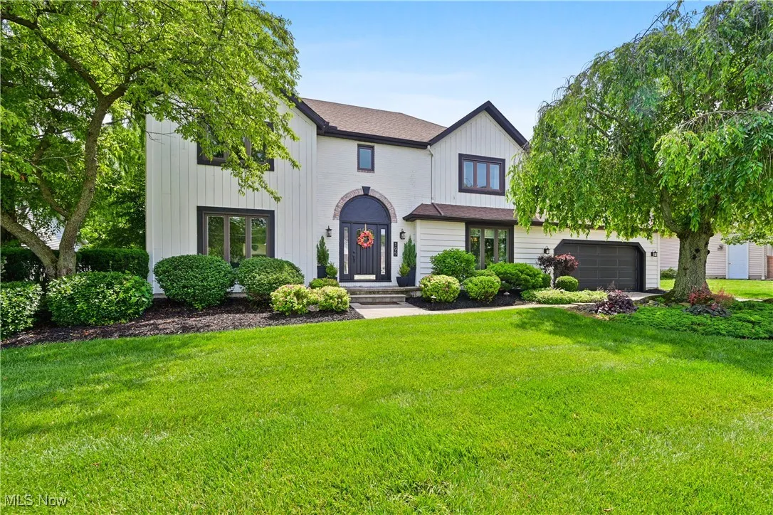 Modern farmhouse style home featuring a front yard, a garage, and board and batten siding