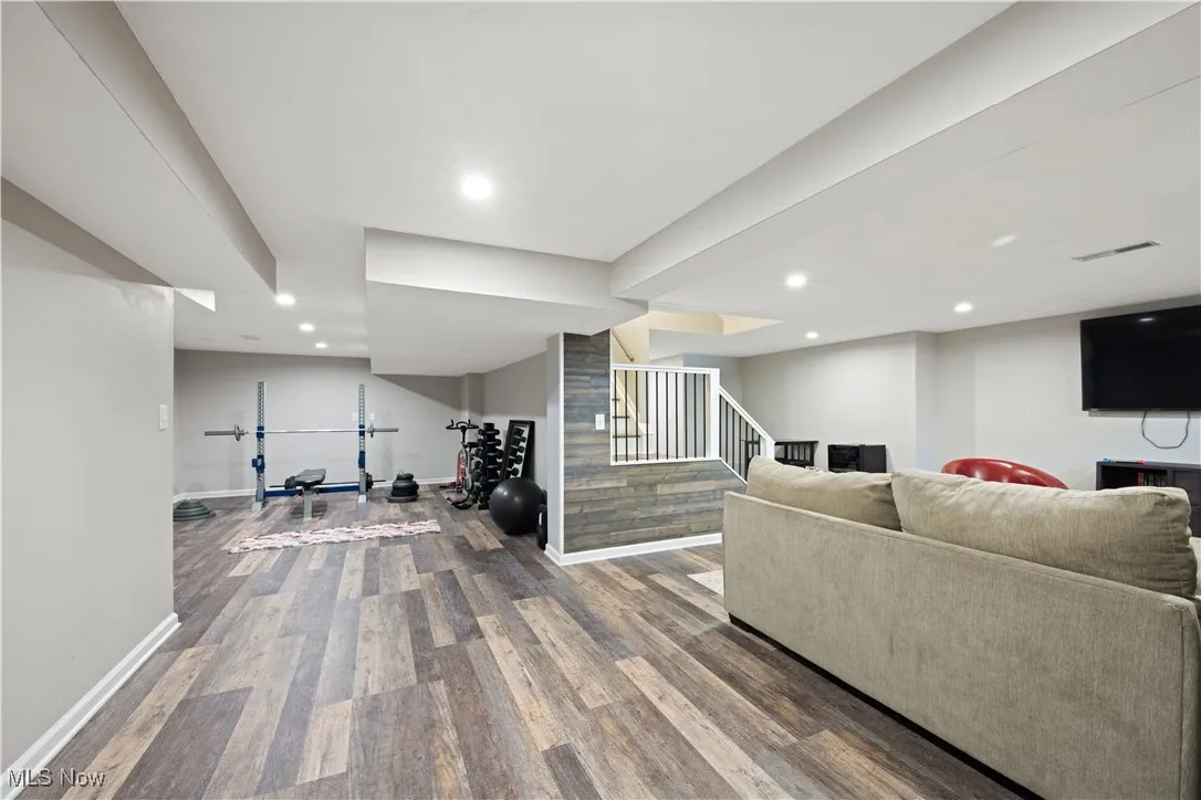 Living area with stairway, wood finished floors, and recessed lighting