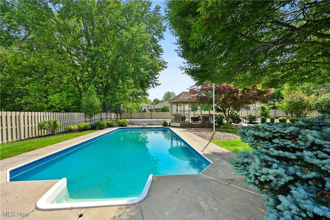 View of pool featuring a gazebo, a fenced backyard, and a patio