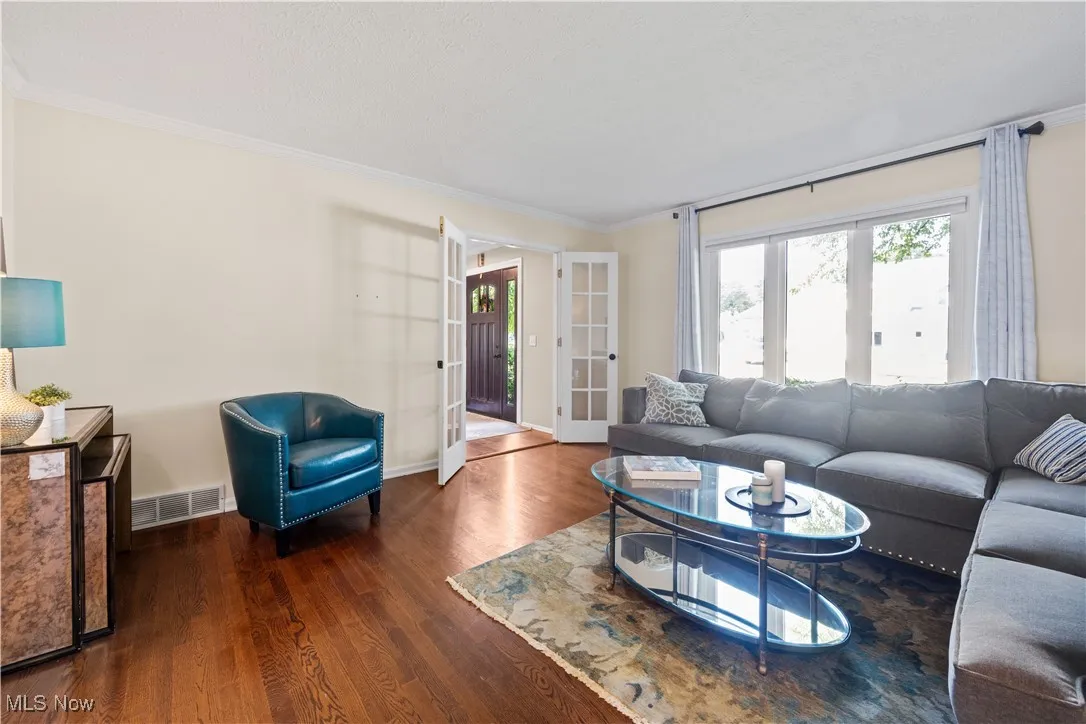 Living area featuring ornamental molding, wood finished floors, and french doors