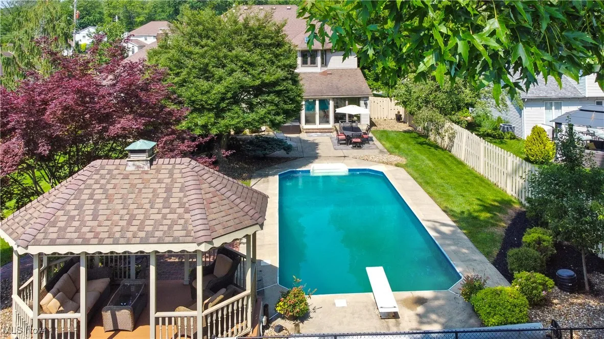 View of swimming pool with a gazebo, a fenced backyard, outdoor lounge area, a patio, and a diving board